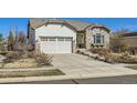 Inviting curb appeal with a well-maintained lawn, stone accents, and a spacious two-car garage at 16494 Aliante Dr, Broomfield, CO 80023