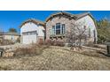 A close-up view of the property showing the stone and stucco exterior details and attractive landscaping at 16494 Aliante Dr, Broomfield, CO 80023