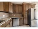 A view of the kitchen featuring granite countertops, stainless steel appliances, and wood cabinets at 6671 Oneida St, Commerce City, CO 80022