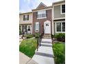 Charming townhouse featuring a well-manicured lawn and inviting entryway with concrete stairs and black railings at 1699 S Trenton St # 69, Denver, CO 80231