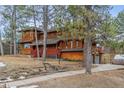 Beautiful multi-story home with a red porch, mature trees, a driveway, and an attached garage at 8170 Lt William Clark Rd, Parker, CO 80134