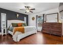 Comfortable main bedroom with hardwood floors, rustic furniture, accent wall and a ceiling fan at 8170 Lt William Clark Rd, Parker, CO 80134