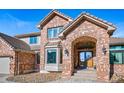 Inviting brick home entrance with archway and a charming front door at 9 Mule Deer Trl, Littleton, CO 80127