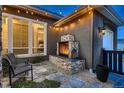 Serene backyard patio with stone fireplace, perfect for outdoor entertaining and relaxation under string lights at 9521 Garnett Way, Arvada, CO 80007