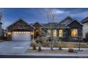 Charming single-Gathering home boasts meticulous landscaping and a welcoming front facade at twilight at 9521 Garnett Way, Arvada, CO 80007