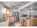 Well-lit kitchen featuring stainless steel appliances, granite countertops, and wood-style flooring at 1004 W Shepperd Ave, Littleton, CO 80120