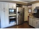 Modern kitchen featuring stainless steel appliances, sleek white cabinetry, and a built-in microwave and oven at 12931 W Florida Dr, Lakewood, CO 80228
