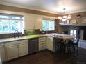 Stylish kitchen with white cabinets, stainless steel dishwasher, and a cozy breakfast nook area with barstool seating at 12931 W Florida Dr, Lakewood, CO 80228