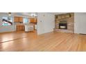 Inviting open-concept living space featuring hardwood floors and a charming brick fireplace at 9359 Barnes Ave, Conifer, CO 80433