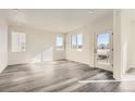 Bright and airy living room with modern gray laminate flooring and ample natural light at 1296 S Algonquian, Aurora, CO 80018