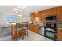 Open-concept kitchen with a breakfast bar, stainless steel appliances, and ample cabinet space at 1539 S Quail St, Denver, CO 80232