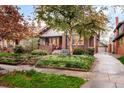 Beautiful brick home with landscaped front yard, mature trees, and inviting front porch at 730 Cook St, Denver, CO 80206