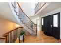 Inviting foyer with wood floors, curved staircase with iron railings, and a view into the living room at 1881 Alma Ln, Superior, CO 80027