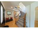 Foyer with wood floors, curved staircase with iron railings, and bench seating with red pillows at 1881 Alma Ln, Superior, CO 80027