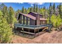 Exterior view of a mountain home featuring a spacious deck with stunning views at 11333 Conifer Mountain Rd, Conifer, CO 80433