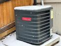 Goodman air conditioner unit covered in snow, highlighting the home's climate control system at 18336 E Amherst Dr, Aurora, CO 80013