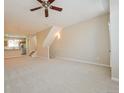 Spacious living area featuring neutral carpet, staircase with modern lighting, flowing to kitchen at 9300 E Florida Ave # 1506, Denver, CO 80247