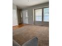 Bright living area featuring a large window, neutral walls, plush carpet, and natural light at 5201 E 127Th Dr, Thornton, CO 80241