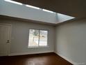 Bright living room featuring hardwood floors, a skylight and a large window offering outside views at 6396 S Hill St, Littleton, CO 80120