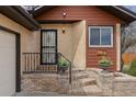 Inviting front porch with brick steps and decorative planters, leading to a secure front door at 673 Brentwood St, Lakewood, CO 80214