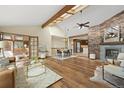 Sun-filled living room boasts hardwood floors, a stone fireplace, and access to an outdoor deck at 673 Brentwood St, Lakewood, CO 80214