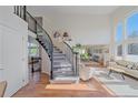 Bright entryway featuring a staircase with black railings, hardwood floors, and large windows, creating an inviting space at 10127 W 100Th Ct, Westminster, CO 80021