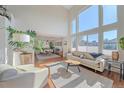 Sunlit living room with high ceilings, large windows, hardwood floors, and a modern sofa, perfect for relaxation at 10127 W 100Th Ct, Westminster, CO 80021