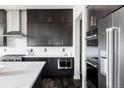 Modern kitchen boasting stainless steel appliances, dark cabinets, quartz countertops, and ample storage at 9388 E 59Th Pl, Denver, CO 80238