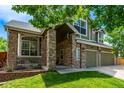 Inviting home exterior with beautiful stone columns, covered porch, well-maintained lawn, and mature trees at 1588 W 111Th Ave, Northglenn, CO 80234