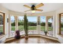 Bright sun room with large windows offering mountain views, tiled flooring, and a ceiling fan at 1069 Crestmoor Dr, Boulder, CO 80303