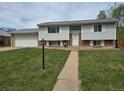 Classic two-story home featuring light siding, brick accents, and a two car garage at 465 Salem St, Aurora, CO 80011