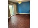 Bright living room featuring wood floors, access to the backyard, and a large window for natural light at 14096 E Radcliff Cir, Aurora, CO 80015
