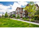 Neighborhood street view with well-maintained lawns and beautiful landscaping at 1125 Anker Dr, Erie, CO 80516