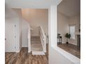 Bright entryway featuring hardwood floors, staircase, and open view to the living area at 2217 S Nome Ct, Aurora, CO 80014