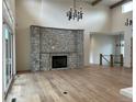 Open-concept living room with a stone fireplace, high ceilings, and hardwood floors offers a cozy atmosphere at 5841 Powell Rd, Parker, CO 80134