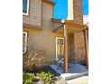 Side view of the home's entrance, with brick and wood design with a chair and a small garden at 886 Summer Dr, Highlands Ranch, CO 80126