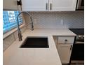Up close view of kitchen with stainless steel faucet and sink, and tiled backsplash at 886 Summer Dr, Highlands Ranch, CO 80126