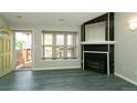Living room with fireplace, large window, open doorway, and blue luxury vinyl flooring at 9617 W Chatfield Ave # E, Littleton, CO 80128