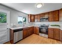 Bright kitchen featuring wood cabinets, stainless steel appliances, and hardwood floors at 4660 E Briarwood Pl, Centennial, CO 80122
