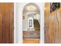 Inviting foyer with hardwood floors, arched doorway, and a glimpse of the staircase adds to the charm of this home at 1137 S Gilpin St, Denver, CO 80210