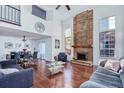 Bright living room with hardwood floors, fireplace, soaring ceilings, and a seamless transition to the dining area at 14120 E Warren Pl, Aurora, CO 80014