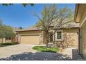 Home exterior showing the driveway and garage with beautiful landscaping and mature trees at 6114 Salvia Ln, Arvada, CO 80403
