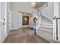 Bright foyer showcases a curved staircase, wood floors, and a stylish light fixture at 11930 E Lake Cir, Greenwood Village, CO 80111