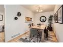 Dining area featuring wood floors, modern light fixture and adjacent kitchen at 1773 S Union Blvd, Lakewood, CO 80228