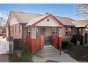 Inviting brick home with covered porch, landscaped yard, and charming architectural details at 1556 Osceola St, Denver, CO 80204