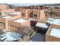 Eye-level shot of stucco home with flat roof and attached garage in front of red rock formations at 10576 Roxborough Dr, Littleton, CO 80125