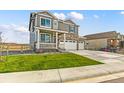 Two-story house with a two-car garage, landscaping, and a front yard at 7548 E 159Th Pl, Thornton, CO 80602