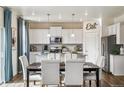 Modern kitchen with white cabinets, granite countertops, and an island at 7548 E 159Th Pl, Thornton, CO 80602