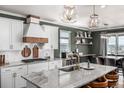 Modern kitchen with a granite island, white cabinets, and stainless steel appliances at 1825 Wingfeather Ln, Castle Rock, CO 80108