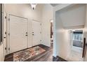 Inviting entryway featuring hardwood floors, neutral walls, high ceilings, and a view into the downstairs bathroom at 4349 S Genoa Ct, Centennial, CO 80015